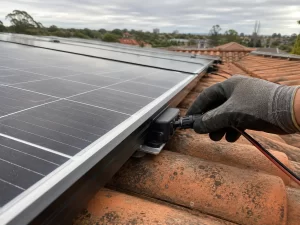 Close-up of solar panels on a tiled roof with an installer checking wiring
