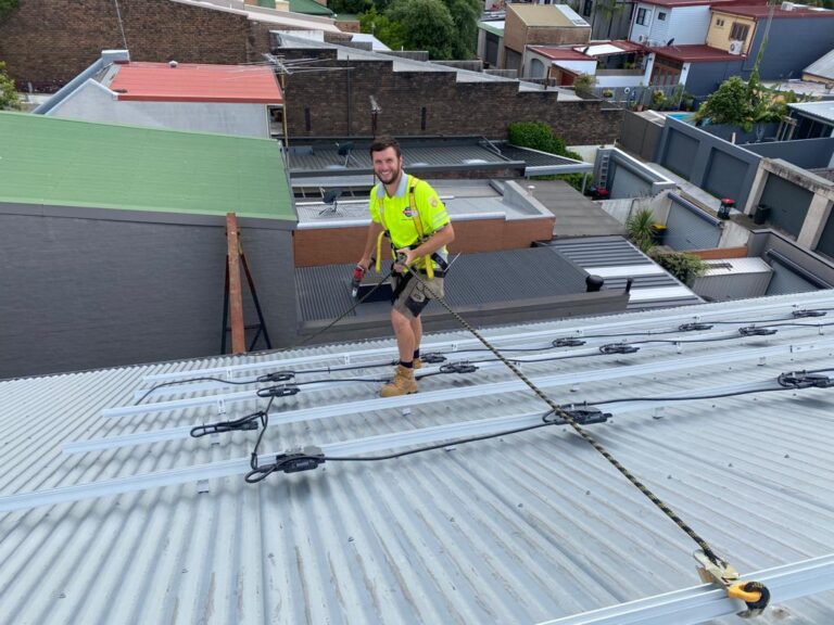 Roofer installing solar panel mounting rails on roof