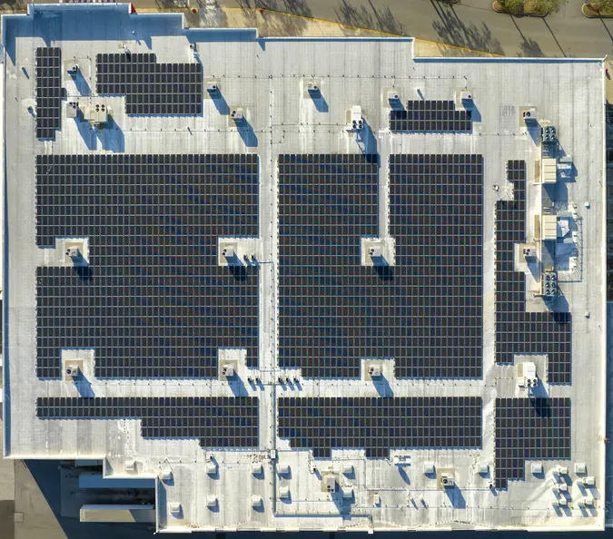 Aerial view of a large commercial solar installation on an industrial roof