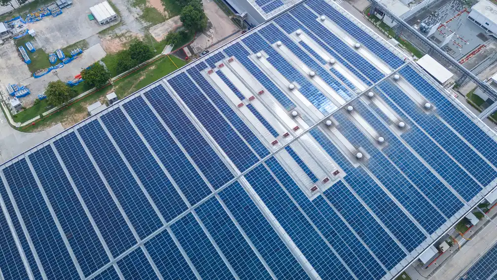 Aerial view of a warehouse roof covered with commercial solar panels
